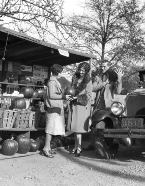 1920s Couple Women Man At Roadside Produce Stand Buying Pumpkins